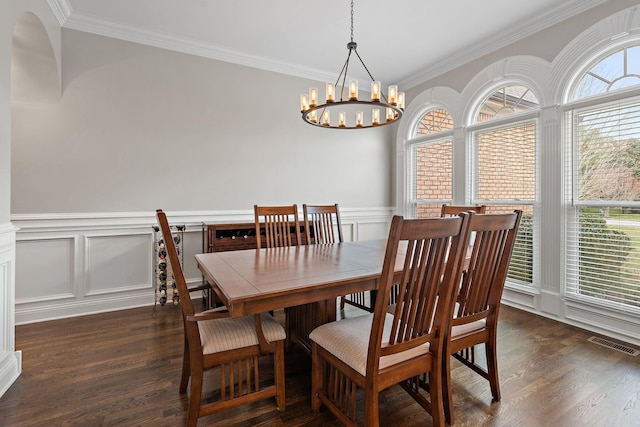 dining room featuring a notable chandelier, ornamental molding, and dark hardwood / wood-style floors