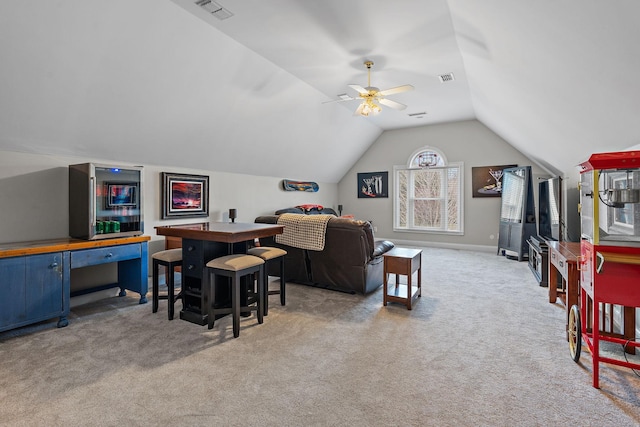 interior space featuring ceiling fan, vaulted ceiling, and light colored carpet