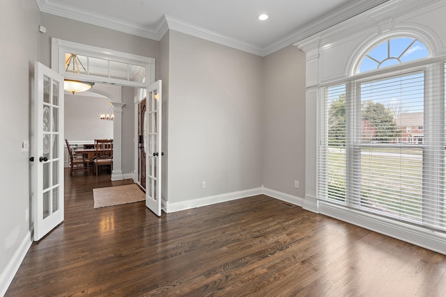 empty room with dark hardwood / wood-style floors, french doors, plenty of natural light, and ornamental molding