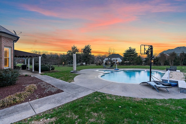 pool at dusk featuring a lawn, a patio area, and a gazebo