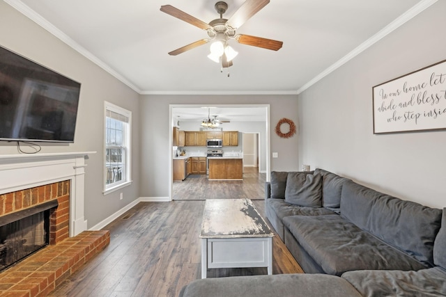 living room featuring ceiling fan, crown molding, a brick fireplace, and hardwood / wood-style floors