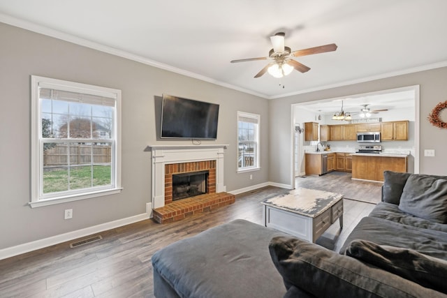 living room with hardwood / wood-style flooring, plenty of natural light, and ornamental molding