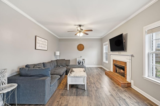 living room featuring ornamental molding, plenty of natural light, dark wood-type flooring, and a brick fireplace