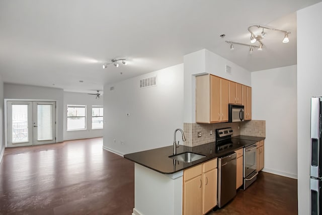 kitchen with kitchen peninsula, sink, tasteful backsplash, appliances with stainless steel finishes, and light brown cabinetry