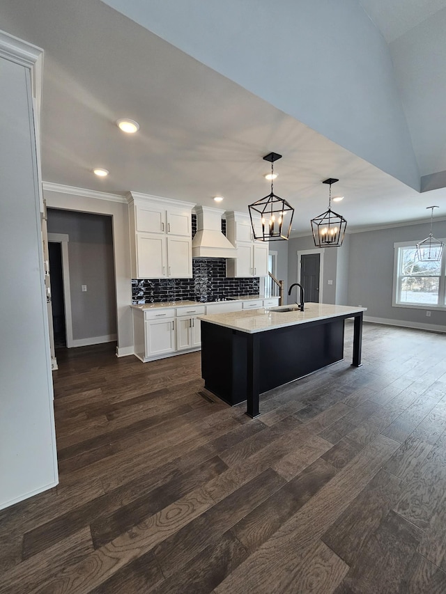 kitchen with dark wood-style floors, light countertops, backsplash, white cabinets, and premium range hood