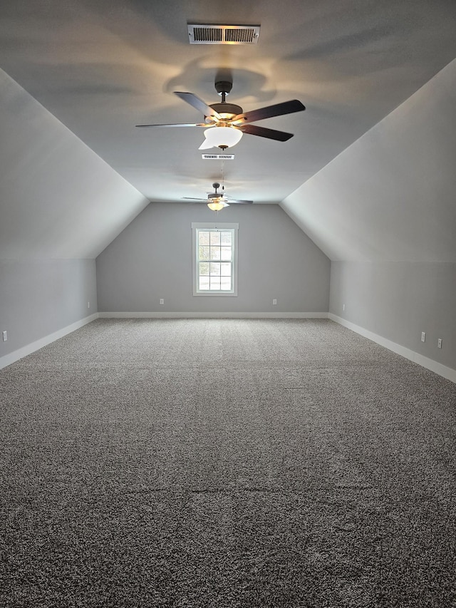 additional living space featuring vaulted ceiling, carpet floors, visible vents, and baseboards