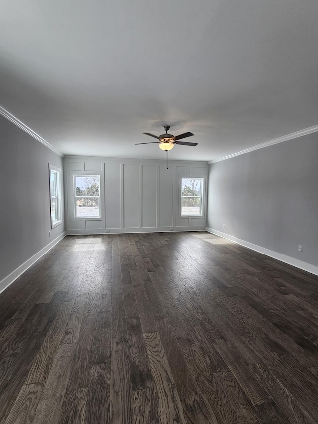 unfurnished living room with dark wood-type flooring, a wealth of natural light, and crown molding