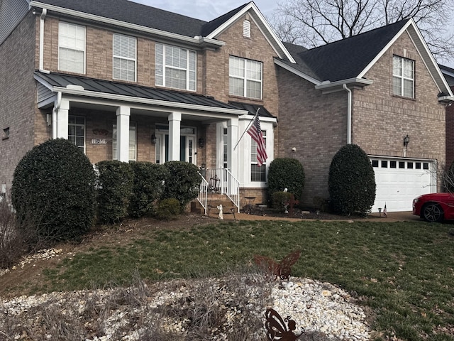 view of front of house featuring covered porch, a front lawn, and a garage