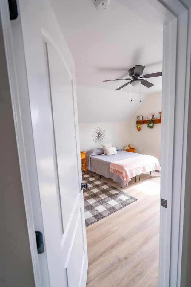 bedroom featuring light hardwood / wood-style floors and lofted ceiling