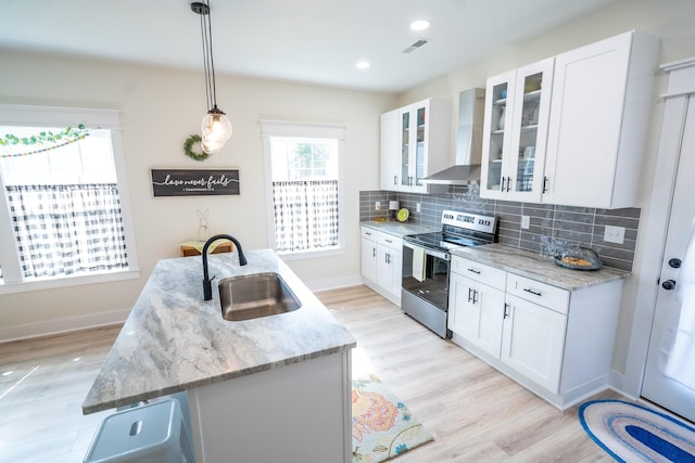 kitchen featuring sink, wall chimney range hood, stainless steel electric stove, and white cabinets