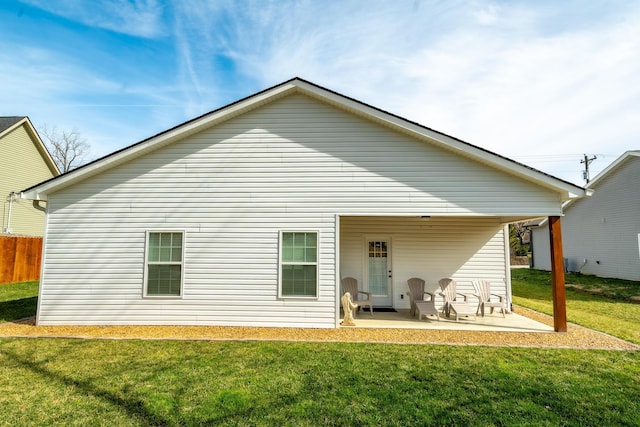 rear view of property featuring a lawn and a patio area