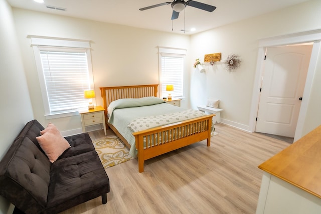 bedroom with light wood-type flooring, ceiling fan, and multiple windows