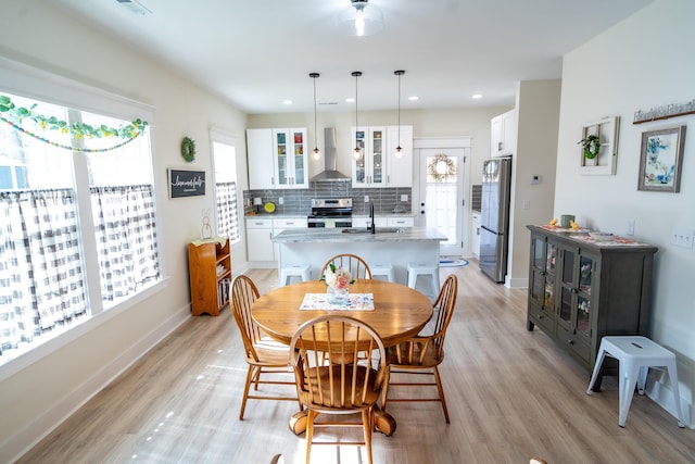 dining area with sink and light hardwood / wood-style floors