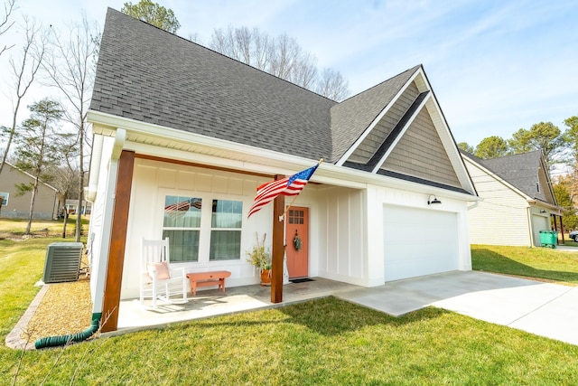 view of front of home featuring central AC, a front lawn, and a garage