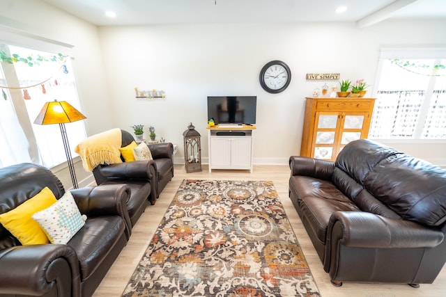 living room with beamed ceiling and light hardwood / wood-style floors