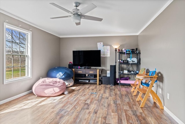 recreation room with hardwood / wood-style flooring, ceiling fan, and ornamental molding