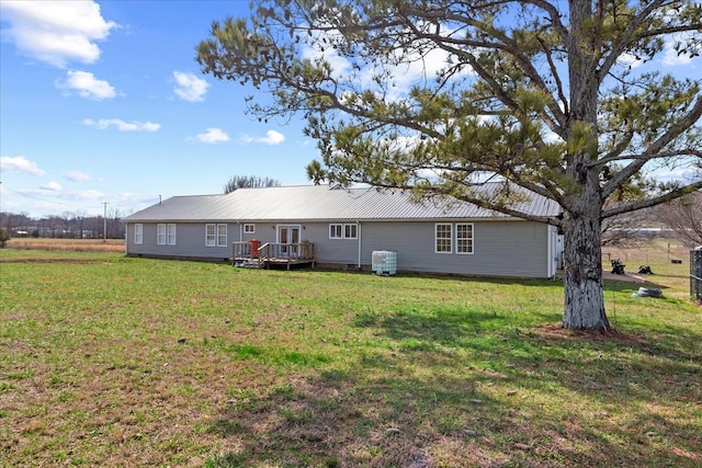 back of property with a deck and a lawn