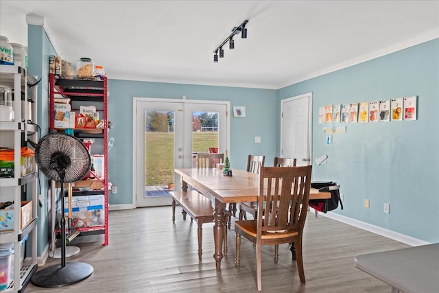 dining room with french doors, track lighting, and wood-type flooring