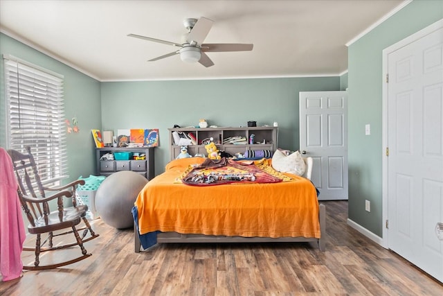 bedroom featuring hardwood / wood-style floors, crown molding, and ceiling fan