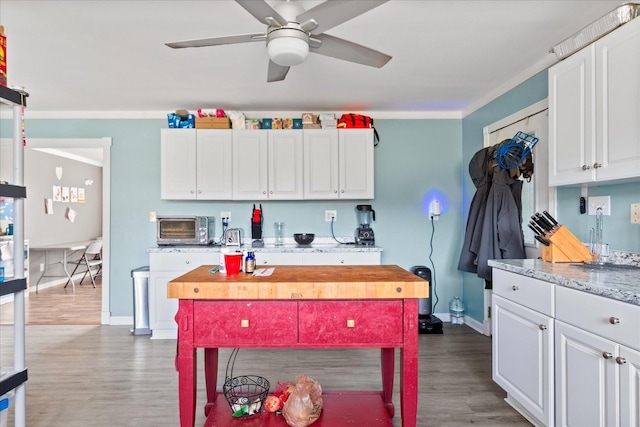 kitchen featuring white cabinetry, wood-type flooring, and wood counters