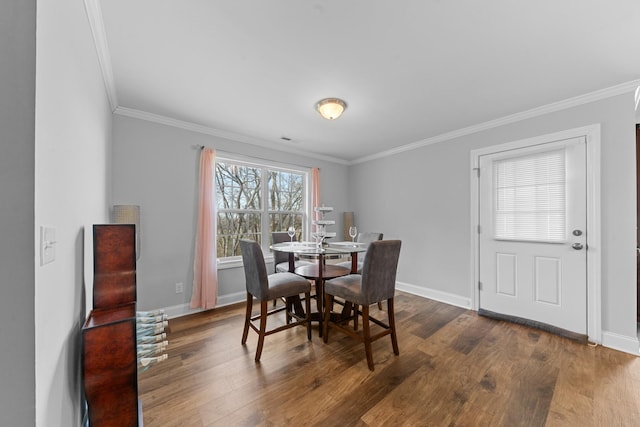 dining space with dark hardwood / wood-style flooring and ornamental molding