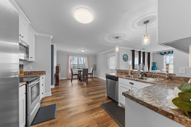 kitchen with sink, white cabinetry, stainless steel appliances, and pendant lighting