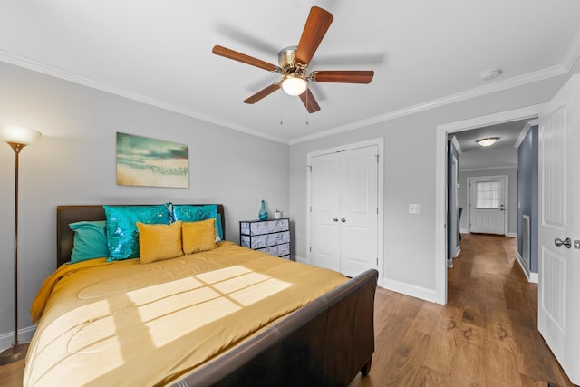 bedroom featuring hardwood / wood-style floors, ceiling fan, a closet, and crown molding