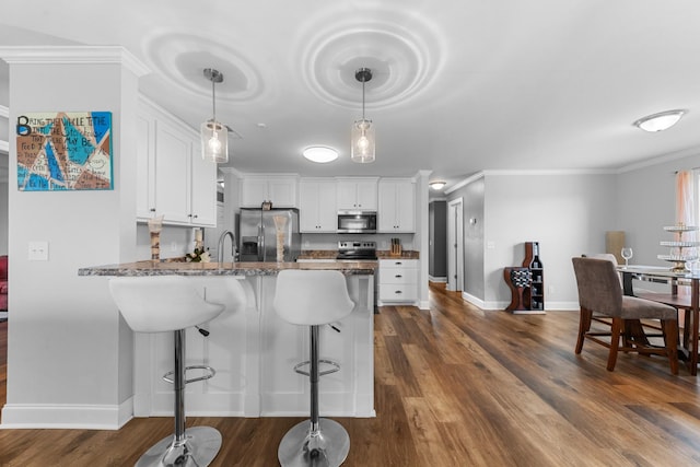 kitchen featuring dark stone countertops, dark wood-type flooring, stainless steel appliances, and white cabinets