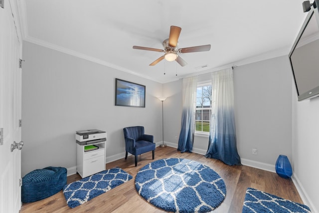 living area featuring ornamental molding, hardwood / wood-style floors, and ceiling fan