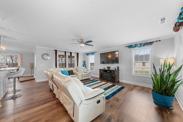 living room with plenty of natural light, crown molding, and dark hardwood / wood-style floors