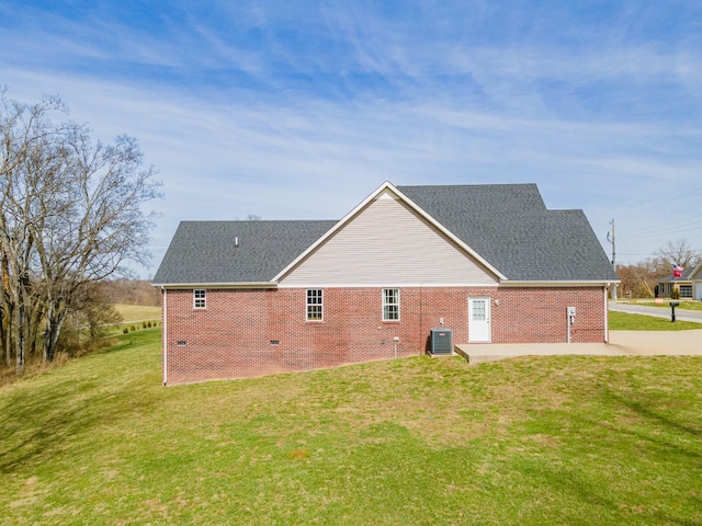 view of side of home featuring a patio, a lawn, and central air condition unit