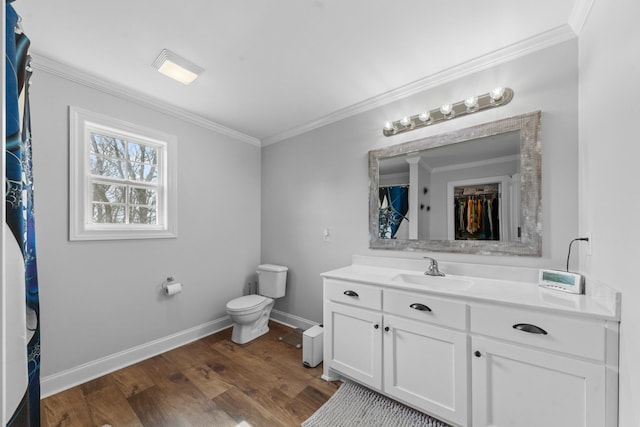 bathroom featuring toilet, vanity, crown molding, and wood-type flooring