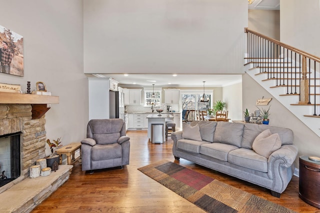 living room with a fireplace, dark hardwood / wood-style floors, and a towering ceiling