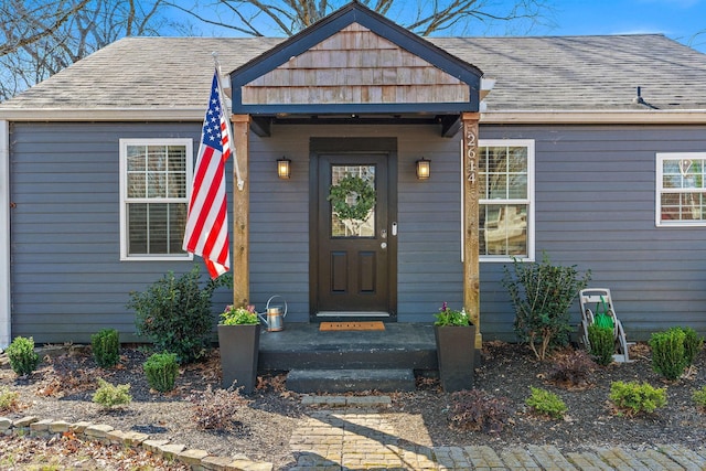 doorway to property with a shingled roof