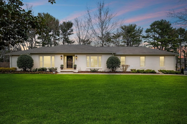 single story home with a front lawn and brick siding