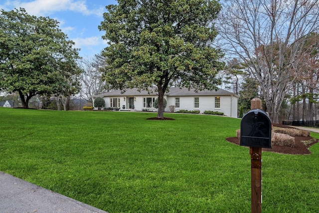 single story home featuring a front lawn