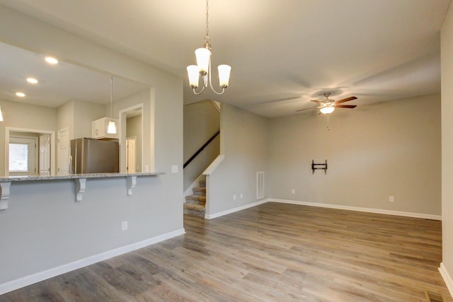 unfurnished living room with recessed lighting, a ceiling fan, baseboards, light wood-type flooring, and stairs