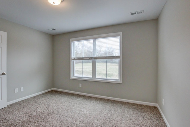 carpeted spare room with baseboards and visible vents