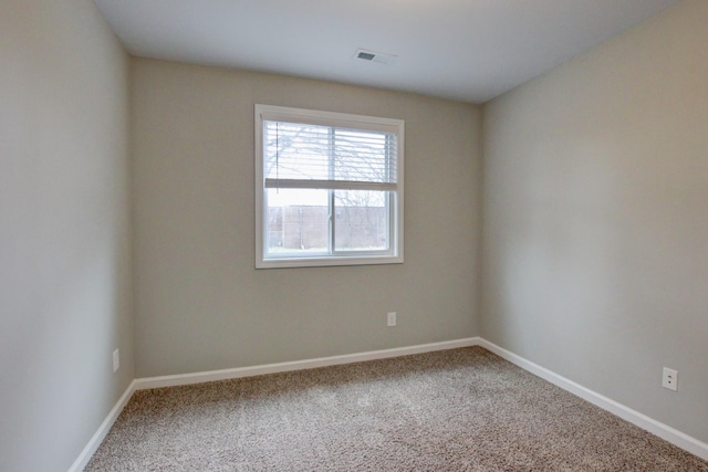 empty room featuring baseboards, visible vents, and carpet