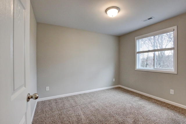 empty room featuring visible vents, baseboards, and carpet