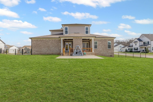 back of house with brick siding, a fenced backyard, a yard, and a patio