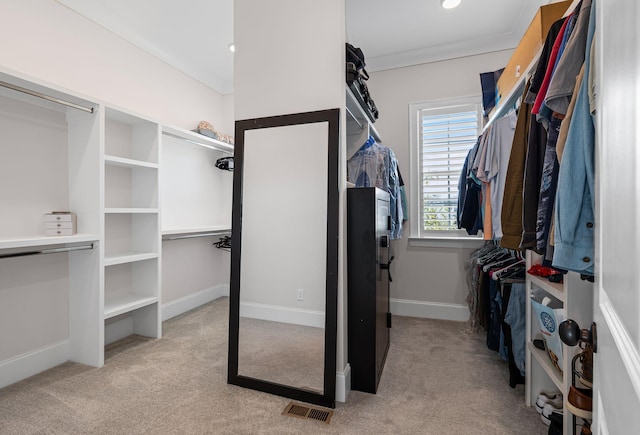 walk in closet with visible vents and light carpet