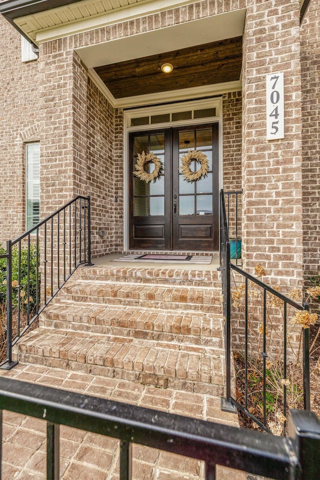 doorway to property featuring brick siding and french doors