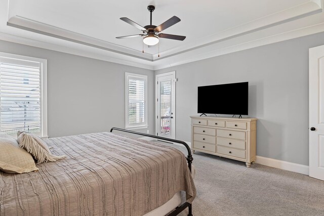 bedroom featuring light colored carpet, a raised ceiling, baseboards, access to exterior, and ceiling fan