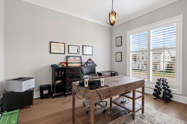 office area with light wood-style flooring, ornamental molding, an inviting chandelier, and baseboards