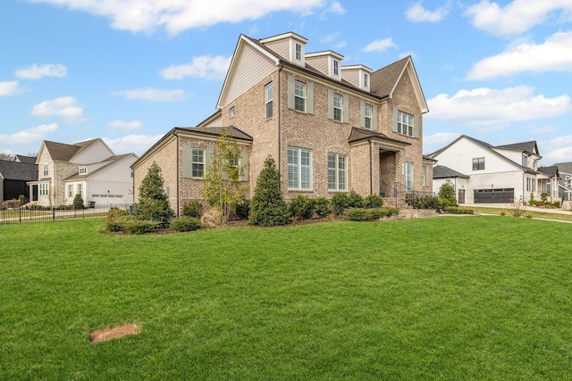 view of front of home featuring fence, a residential view, brick siding, and a front yard