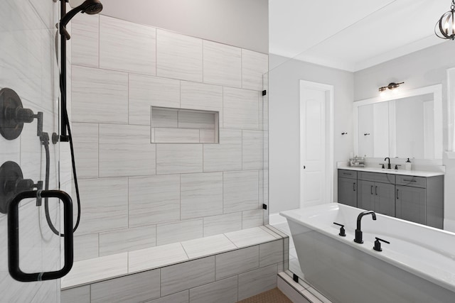 full bath with ornamental molding, vanity, a soaking tub, and tiled shower