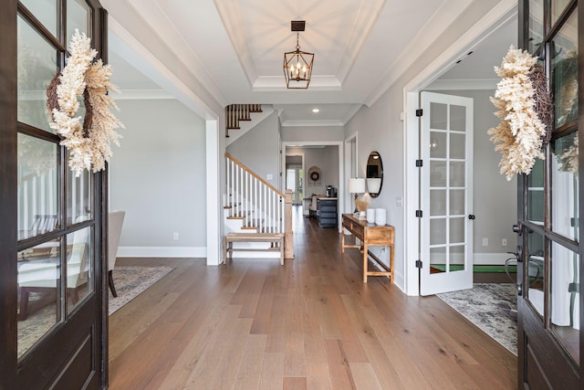 entrance foyer with stairs, an inviting chandelier, french doors, and wood finished floors