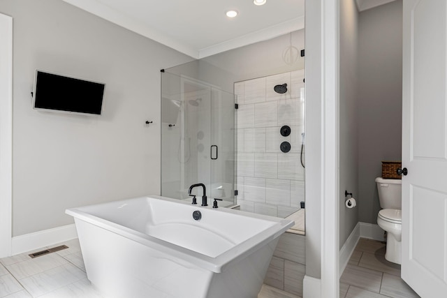 bathroom with visible vents, baseboards, a shower stall, a freestanding bath, and toilet