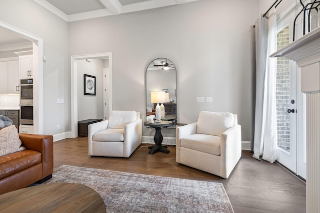 living area with ceiling fan, baseboards, dark wood-style floors, and beam ceiling